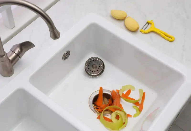 Vegetable peels in a sink garbage disposal